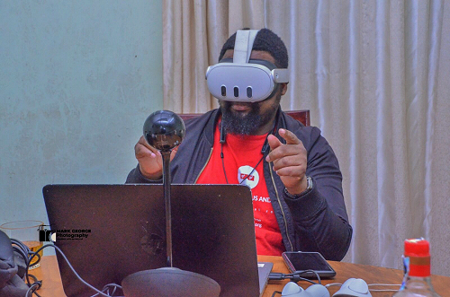 Paul Waiyaki working with his VR headset next to his laptop.